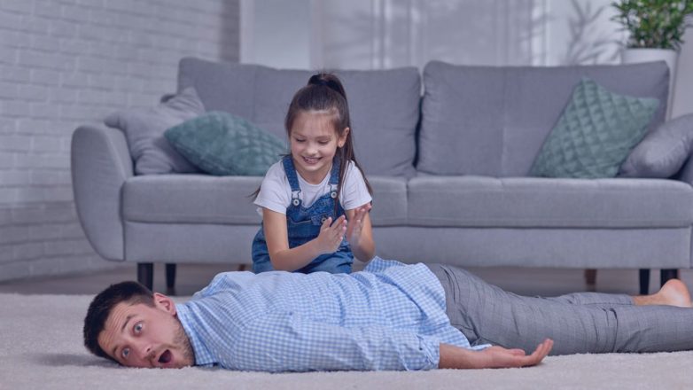 filha criança feliz fazendo massagem para o pai em casa. Dia dos Pais.