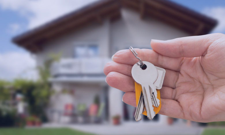 Como comprar sua casa própria: Close-up da pessoa com a mão segurando a chave da casa