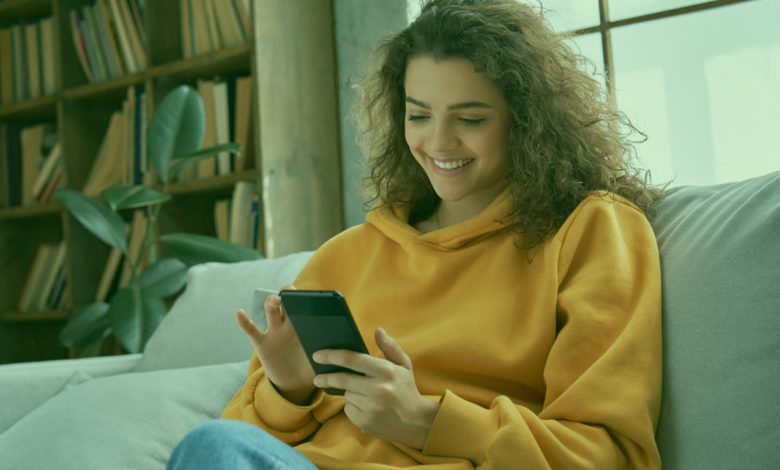 Mulher sorrindo jogando no celular