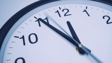relógio análogico de parede mostrando 5min antes das 12 horas