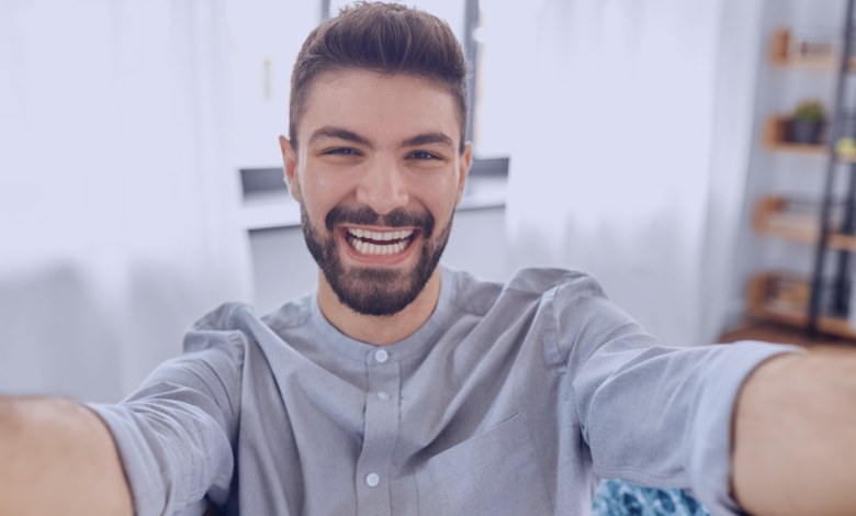 Homem de Gêmeos feliz sorrindo em uma selfie.