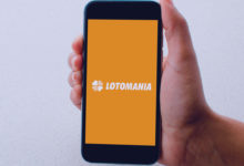 Simpatia para ganhar na Lotomania: mão segurando celular com a palavra lotomania escrita