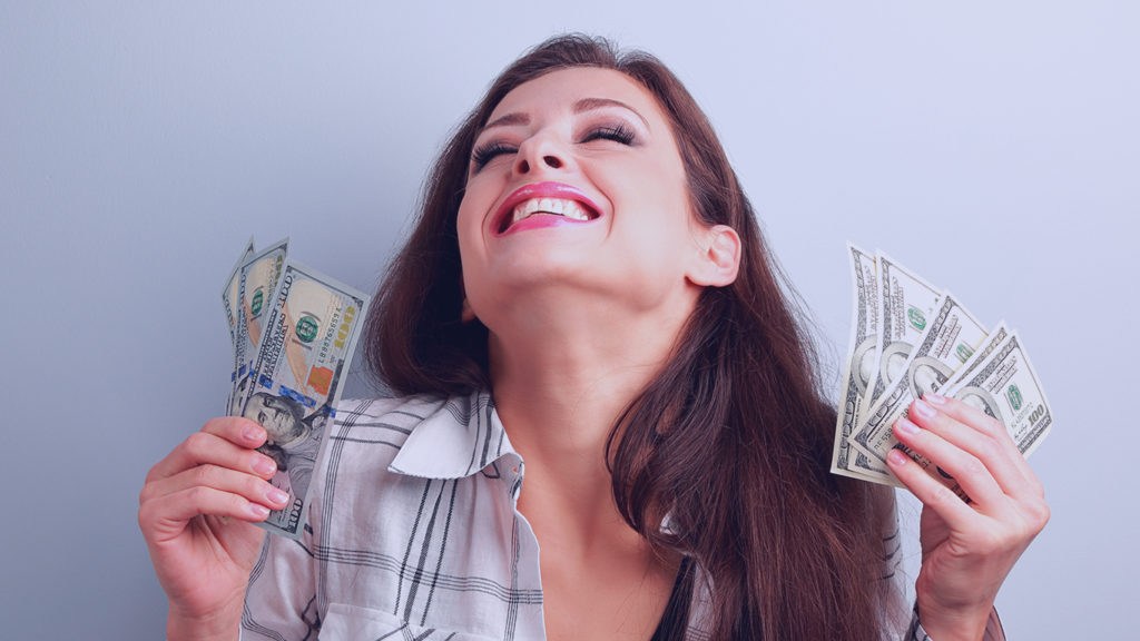 Powerball online: mulher sorrindo com notas de dolares na mao