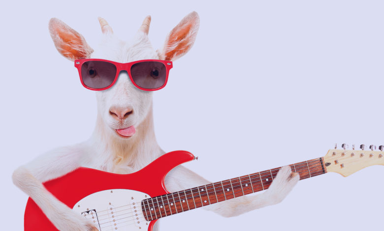 Milhar da cabra que mais sai: retrato divertido de uma cabra segurando uma guitarra